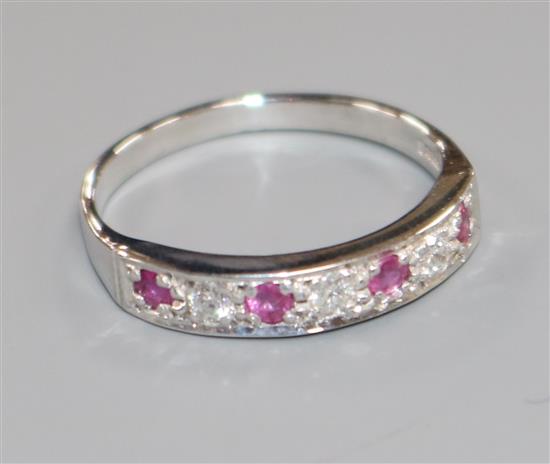 A modern 14ct white gold, seven stone ruby and diamond half hoop ring, size Q/R.